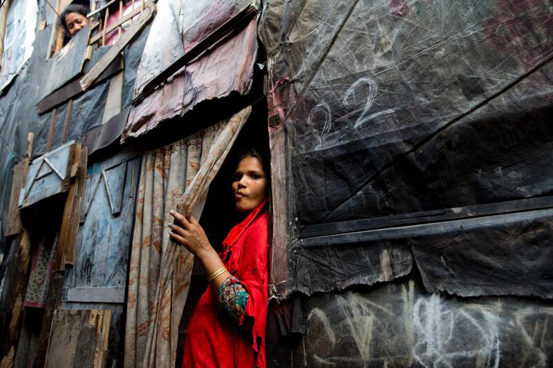 A Rohingya Muslim woman stands by the entrance to her shanty at a camp for refugees in New Delhi, India, Monday, Sept. 18, 2017. India's government said Monday that it has evidence there are extremists who pose a threat to the country's security among the Rohingya Muslims who have fled Myanmar and settled in many Indian cities. India's Supreme Court was hearing a petition filed on behalf of two Rohingya refugees challenging a government decision to deport the ethnic group from India. (AP Photo/Tsering Topgyal)