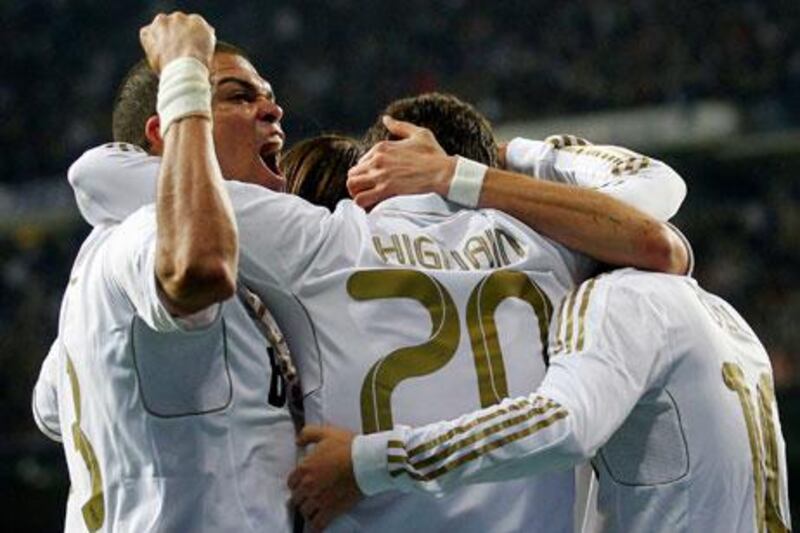 Real Madrid's Pepe, left, and Mesut Ozil embrace Gonzalo Higuain, centre. Along with Cristiano Ronaldo, they have made Real Madrid a team Barcelona cannot ignore.