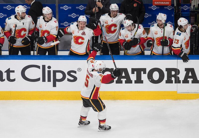 Calgary Flames' Mark Giordano (5) celebrates an empty-net goal with teammates against the Winnipeg Jets during the third period of an NHL qualifying round game, in Edmonton, Alberta. AP Photo
