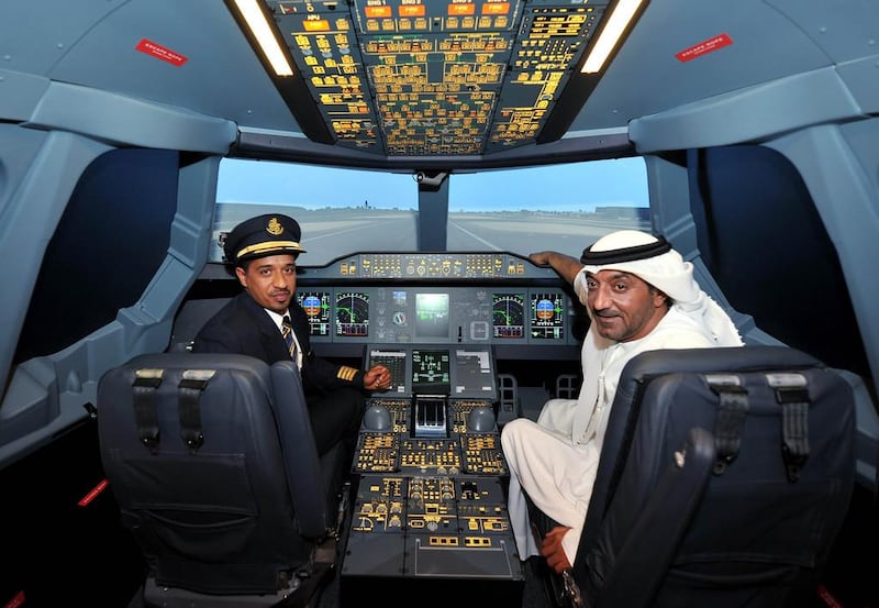 Sheikh Ahmed bin Saeed Al-Maktoum, the chairman and chief executive of Emirates Airline, takes the pilot seat with Captain Moataz Alswaini at the Emirates A380 Experience at The Dubai Mall.