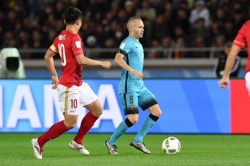 Andres Iniesta controls the ball in front of Guangzhou Evergrande midfielder Zheng Zhi. Toshifumi Kitamura / AFP