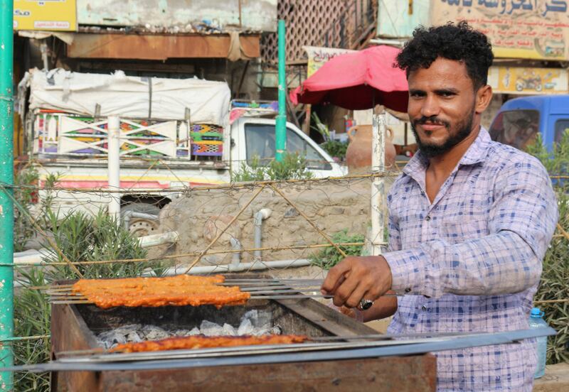 A kebab vendor grills meat on skewers on a steet in Lahj, Yemen.