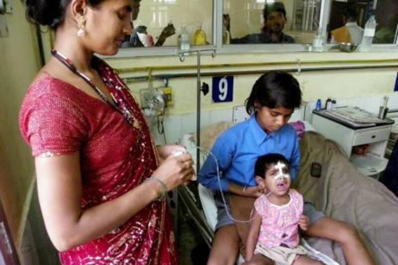 In this Tuesday, April 2, 2013 photo, an Indian child in a pink shirt undergoes treatment for encephalitis at a hospital in Gorakhpur in Uttar Pradesh state, India. Encephalitis is sweeping through northern India, killing at least 118 children in what officials worry could become the deadliest outbreak in nearly a decade. (AP Photo/Biswajeet Banerjee) *** Local Caption ***  India Encephalitis.JPEG-0f560.jpg