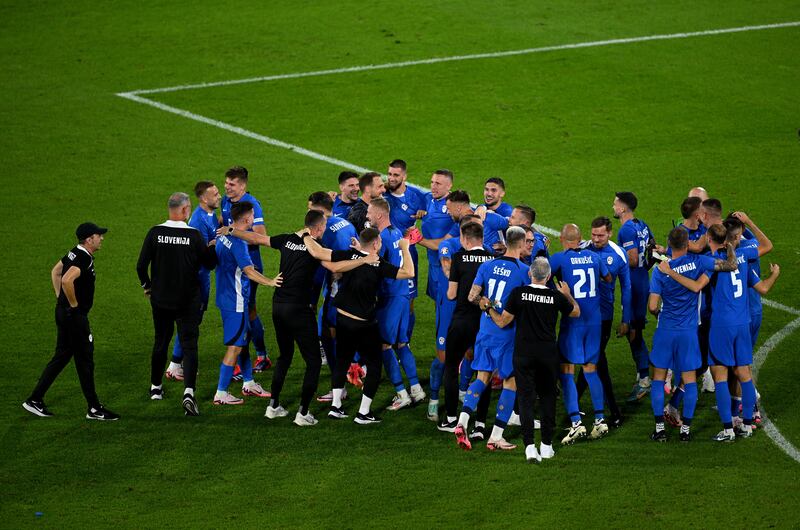 The players and coaching staff of Slovenia celebrate at full-time. Getty Images