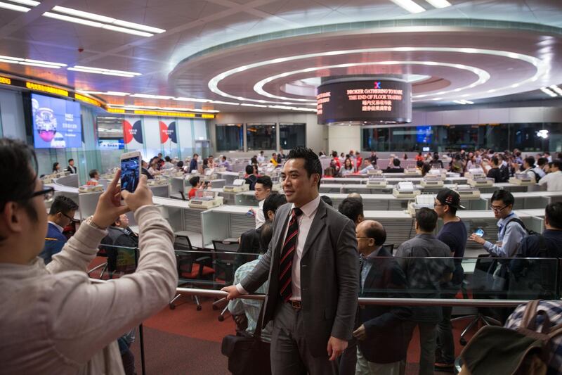 epa06292531 A man poses for a photo in the trading hall of the Hong Kong Exchanges & Clearing Ltd. in Hong Kong, China, 27 October 2017. The day marks the end of an era as the Hong Kong Exchanges and Clearing Ltd. scrapped its iconic trading hall because of little use, as share trading becomes almost entirely electronic. The hall, opened in 1986, once hosted over 900 brokers in its heyday.  EPA/JEROME FAVRE