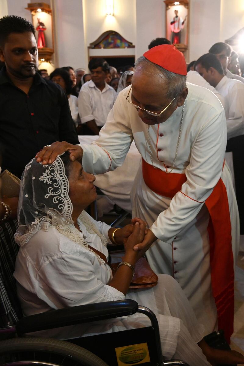 Archbishop of Colombo Malcolm Ranjith blesses a survivor of the Easter Sunday bomb attacks, at midnight mass at St. Sebastian's Church in Negombo.  AFP