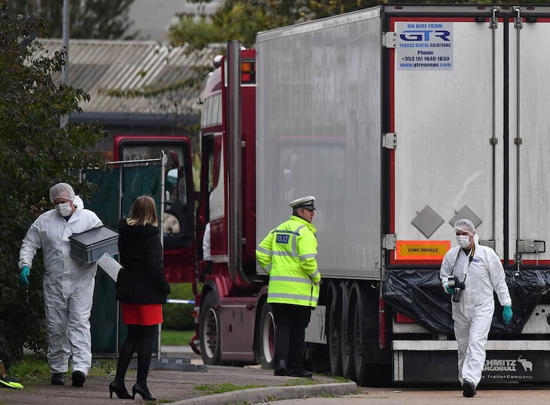 (FILES) In this file photo taken on October 23, 2019 British Police forensics officers work on lorry, found to be containing 39 dead bodies, at Waterglade Industrial Park in Grays, east of London. A 23-year-old man has been charged with human trafficking offences in connection with the deaths of 39 Vietnamese nationals whose bodies were found in a refrigeration truck in Britain. / AFP / Ben STANSALL
