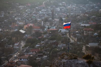 FILE - In this March 28, 2014 file photo, a Russian national flag flies on a hilltop near the city of Bakhchysarai, Crimea. The European Court of Human Rights decided Thursday Jan. 14, 2021, to start considering Ukraine's complaint against alleged human rights violations in the Russia-annexed Crimea. (AP Photo/Pavel Golovkin, File)