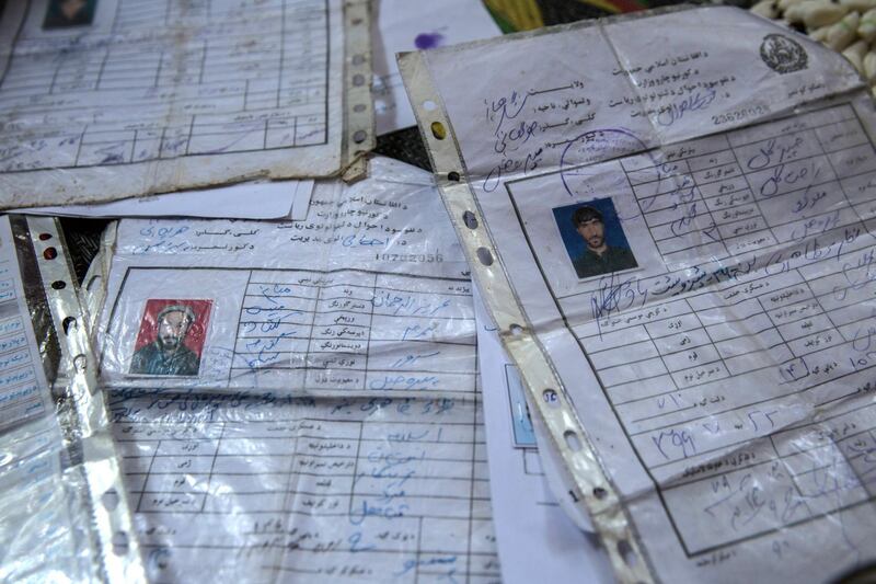 ID cards of the seven peple from Jawari village who were killed in a US drone strike lie on the floor of Rahat Gul's house. 