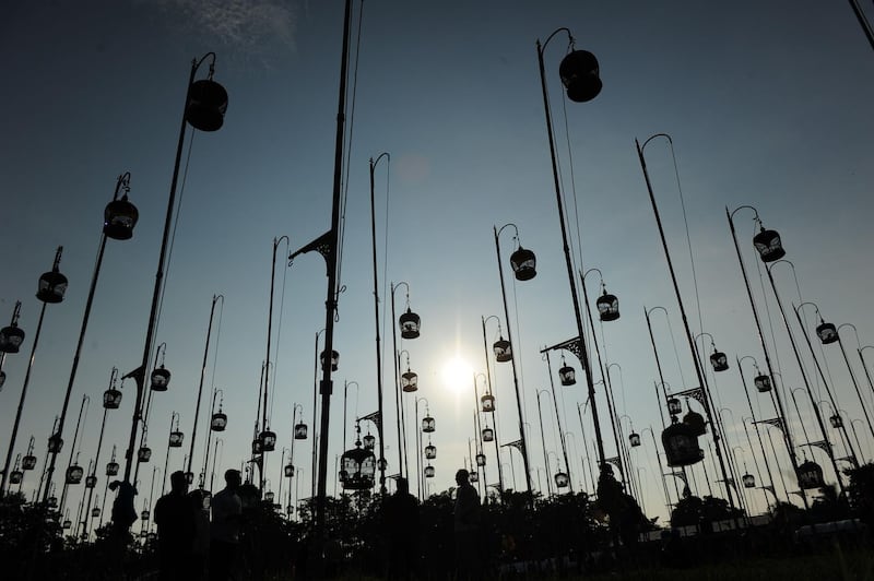 Birdcages are silhouetted against the sky. AFP