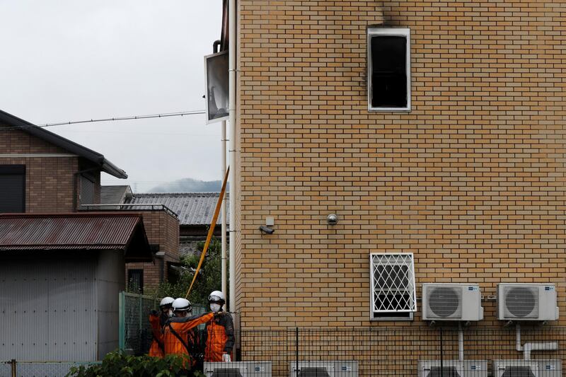 Firefighters check the torched building. Reuters