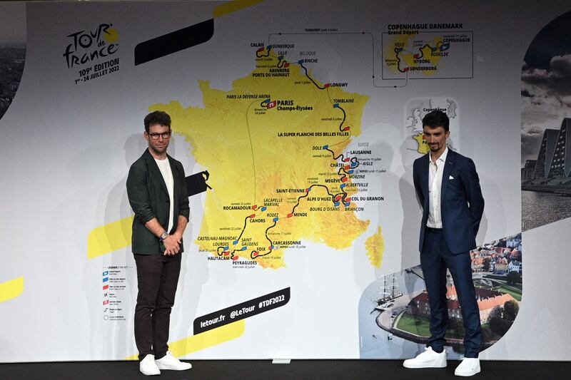 Mark Cavendish and Julian Alaphilippe pose next to the map displaying the 2022 Tour de France route. AFP