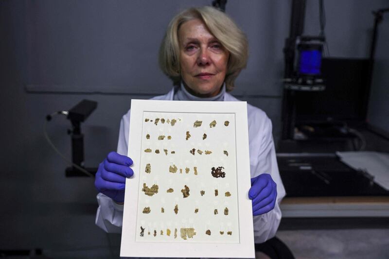Israel Antiquities Authority conservator Tanya Bitler displays recently-discovered 2000-year-old biblical scroll fragments from the Bar Kochba period, after completion of preservation work at the authority's Dead Sea conservation lab in Jerusalem. AFP