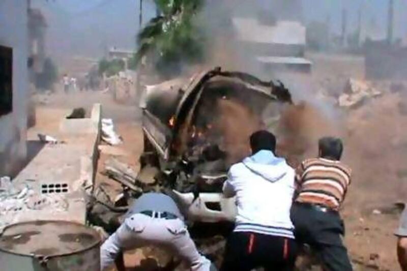 Men extinguish a burning vehicle after shelling in Deraa by Syrian government forces.