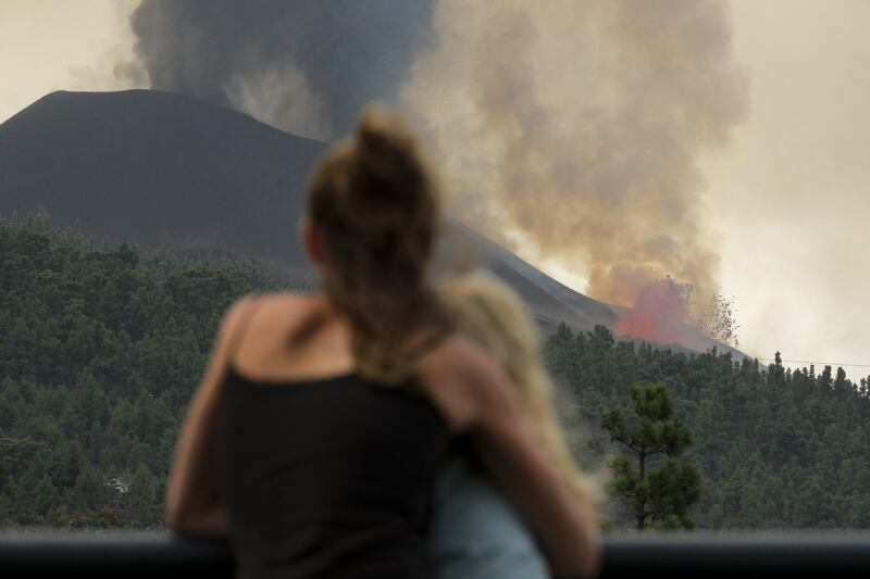 A woman watches the lava coming out of the Cumbre Vieja volcano in La Palma. Photo: EPA