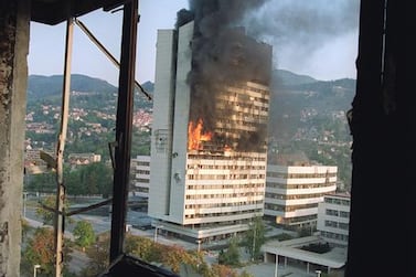 The former Parliament building in Sarajevo burns from Serbian tank fire, in September 1992, as seen from a destroyed upper floor of the Holiday Inn, where most journalists were based. Michael Evstafiev / AFP 
