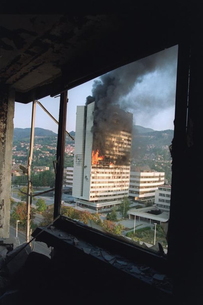 The former Parliament building in Sarajevo burns from Serbian tank fire, in September 1992, as seen from a destroyed upper floor of the Holiday Inn, where most journalists were based. Michael Evstafiev / AFP 