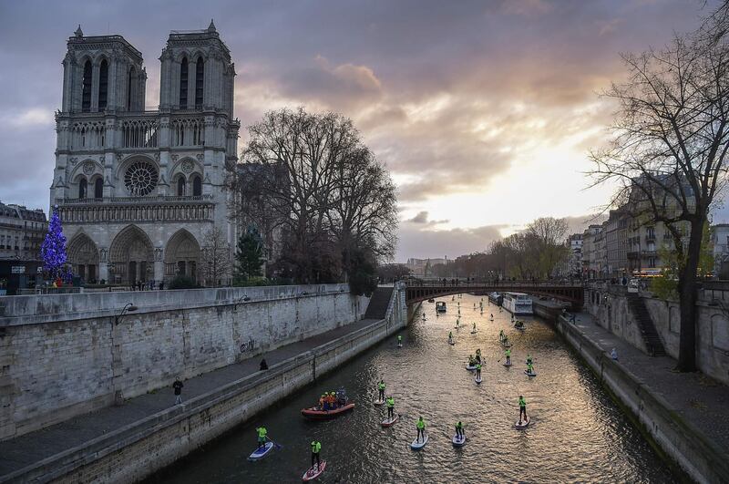Competitors take part in the Nautic Paddle Race on the Seine near Notre-Dame cathedral in Paris..  AFP