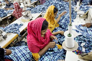 Workers sew plaid shirts on the production line of the Fashion Enterprise garment factory in Dhaka, Bangladesh. Bloomberg