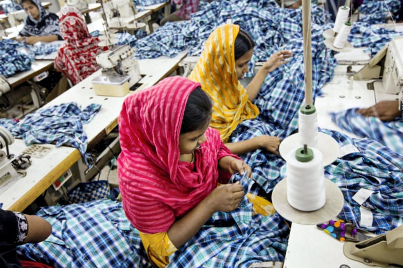 Workers sew plaid shirts on the production line of the Fashion Enterprise garment factory in Dhaka, Bangladesh, on Tuesday, April 30, 2013. Bangladesh authorities said they were accelerating rescue efforts at the factory complex that collapsed last week as hopes fade for more survivors after the nation’s biggest industrial disaster. Bangladesh’s labor law requires safety measures such as fire extinguishers and easily accessible exits at factories. Jeff Holt/Bloomberg