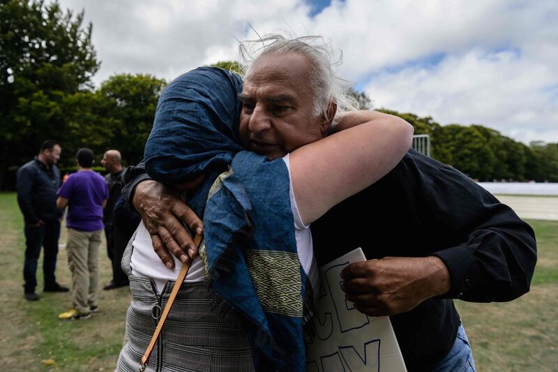 Alaska Wood, 26, (L), and Mohammed Nadir, 58, (R) hug after they were reunited after a two minutes silence and Muslim prayers for twin mosque massacre victims in a park near the Al Noor mosque in Christchurch on March 22, 2019. Alaska had never met Mohammed Nadir prior to the two minutes silence but comforted him as he cried while kneeling down. Nadir's brother Haji Mohammed Daoud Nabi, 71, was the first victim of the Al Noor Mosque massacre and was shot dead after welcoming the gunman into the building with the words "Hello brother". The Muslim call to prayer rang out across New Zealand on Friday followed by two minutes of nationwide silence to mark a week since a white supremacist gunned down 50 people at two mosques in the city of Christchurch. / AFP / ANTHONY WALLACE
