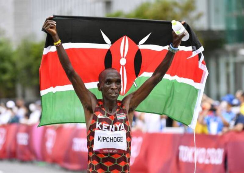 Eliud Kipchoge celebrates with the Kenyan national flag after winning the men's marathon.