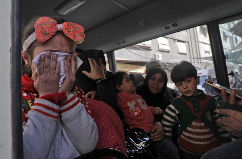 Children wait to be evacuated  in Syrian Red Crescent buses from Douma, Eastern Ghouta. Hamza Al Ajweh / AFP Photo