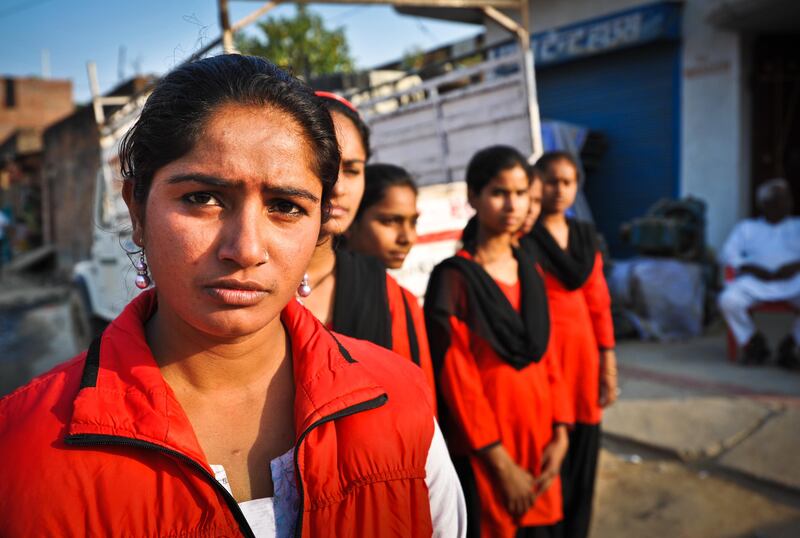 Young women from the Red Brigade walk through the Midiyav slum in the city of Lucknow. Their leader, Usha Vishwakarma, 25, is front left. The Red Brigade was formed in November 2010 to fight back against a growing number of sexual attacks on women in the Madiyav area of the city of Lucknow, in Uttar Pradesh state, India.
The group of young women wear distinctive red and black salwar kameez. Most have been victims of sexual assault and have resolved that they will take no more. They take direct action against their tormentors and now when a local man steps out of line, he can expect a visit from the Red Brigade and a thrashing.