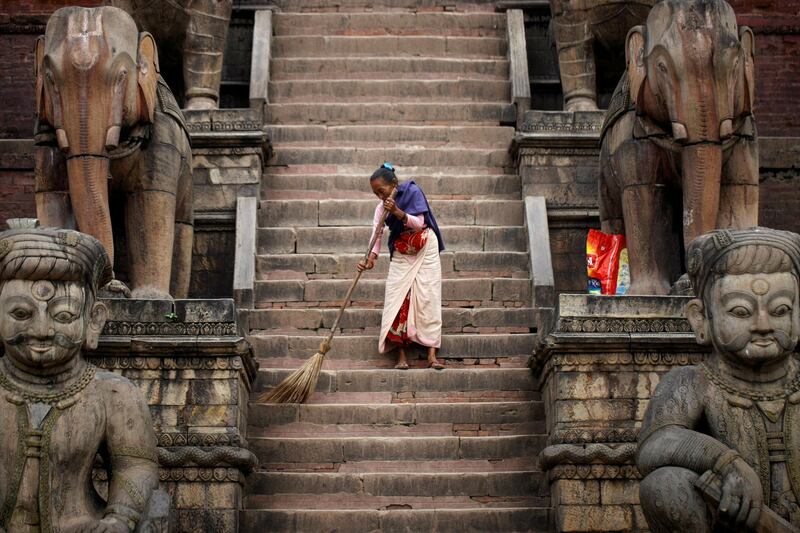 A woman sweeps the premises of Nyatapola Temple in Bhaktapur, Nepal. Reuters