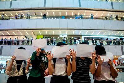 TOPSHOT - Protesters hold up blank papers during a demonstration in a mall in Hong Kong on July 6, 2020, in response to a new national security law introduced in the city which makes political views, slogans and signs advocating Hong Kong’s independence or liberation illegal. Hong Kongers are finding creative ways to voice dissent after Beijing blanketed the city in a new security law and police began making arrests for people displaying now forbidden political slogans. / AFP / ISAAC LAWRENCE
