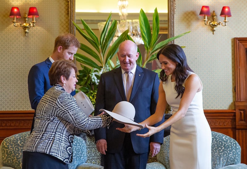 Prince Harry and his Meghan look at bush hats with Australia's Governor General Peter Cosgrove and his wife. AP Photo