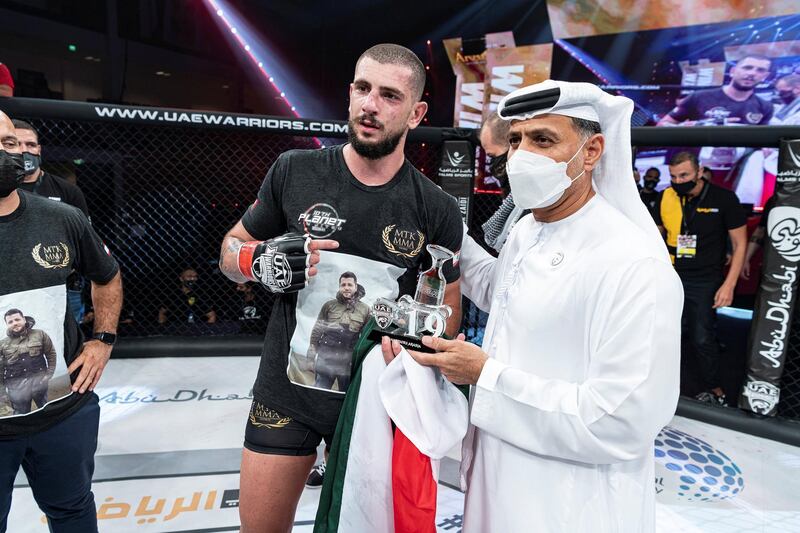 Mohammad Osseili receives the winner’s prize from Abdulmunam Al Hashemi, chairman of Palms Sports. Courtesy UAE Warriors