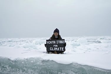Mya-Rose Craig, 18, holds a cardboard sign reading "youth strike for climate" as she sits on the ice floe in the middle of the Arctic Ocean, September 20, 2020. Reuters