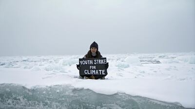 Environmental activist and campaigner Mya-Rose Craig, 18, holds a cardboard sign reading "youth strike for climate" as she sits on the ice floe in the middle of the Arctic Ocean, hundreds of miles above the Arctic Circle, September 20, 2020. REUTERS/Natalie Thomas