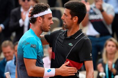 TOPSHOT - Italy's Marco Cecchinato (L) embraces as he celebrates after victory over Serbia's Novak Djokovic in their men's singles quarter-final match on day ten of The Roland Garros 2018 French Open tennis tournament in Paris on June 5, 2018. World number 72 Marco Cecchinato became the first Italian man in 40 years to reach a Grand Slam semi-final with a breathtaking 6-3, 7-6 (7/4), 1-6, 7-6 (13/11) epic victory over 12-time major winner Novak Djokovic.

 / AFP / Eric FEFERBERG
