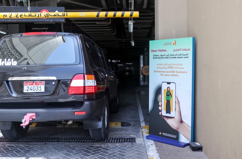 A sign for the new coronavirus scanning system outside Deerfields Mall in Abu Dhabi.