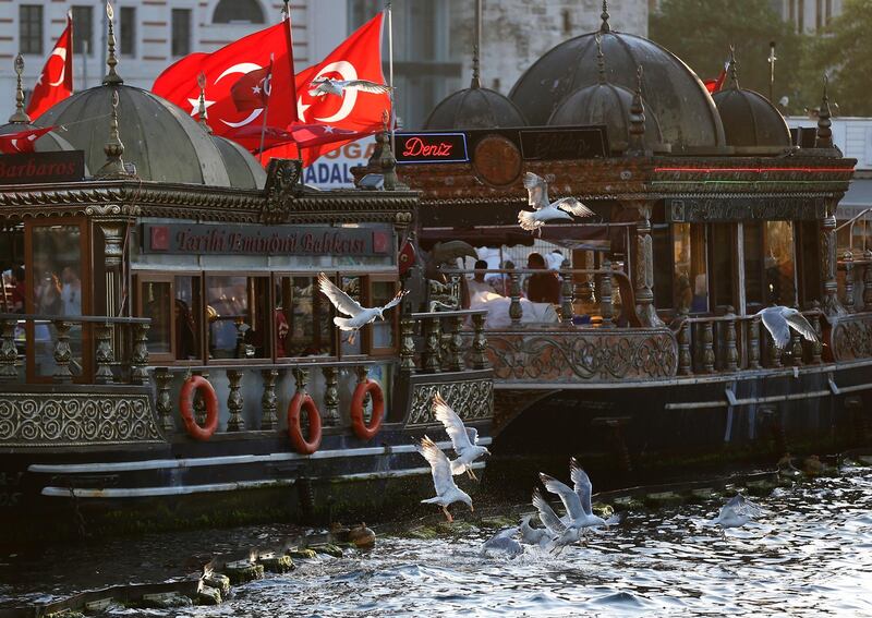 Seagulls fly by fish stalls on the Golden Horn in Istanbul.  AP