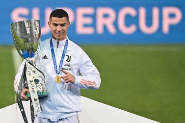 Juventus' Portuguese forward Cristiano Ronaldo poses with the winners' trophy after the Italian Super Cup (Supercoppa italiana) football match between Juventus and Napoli on January 20, 2021 at the Mapei stadium - Citta del Tricolore in Reggio Emilia. The 33rd edition of the Italian football Super Cup is played between Juventus, the winners of the 2019–20 Serie A championship, and Napoli, the winners of the 2019–20 Italian Cup (Coppa Italia). / AFP / MIGUEL MEDINA