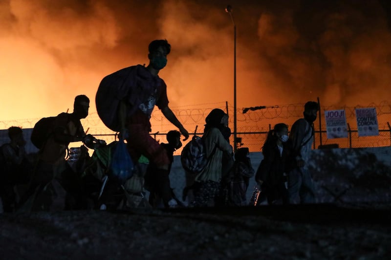 Refugees carry their belongings as they flee from a fire burning at the Moria camp, on the island of Lesbos, Greece. Reuters