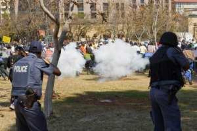 Police fire teargas and rubber bullets at protesting soldiers near the Union Building in Pretoria, South Africa, Wednesday, Aug. 26, 2009, as police tried to stop members of the defense force from marching on the Union Buildings, the seat of government, to protest low wages. Earlier, a court had denied soldiers permission to hold their march but about 3,000 protesters later converged on the lawns below the government building.(AP Photo)
