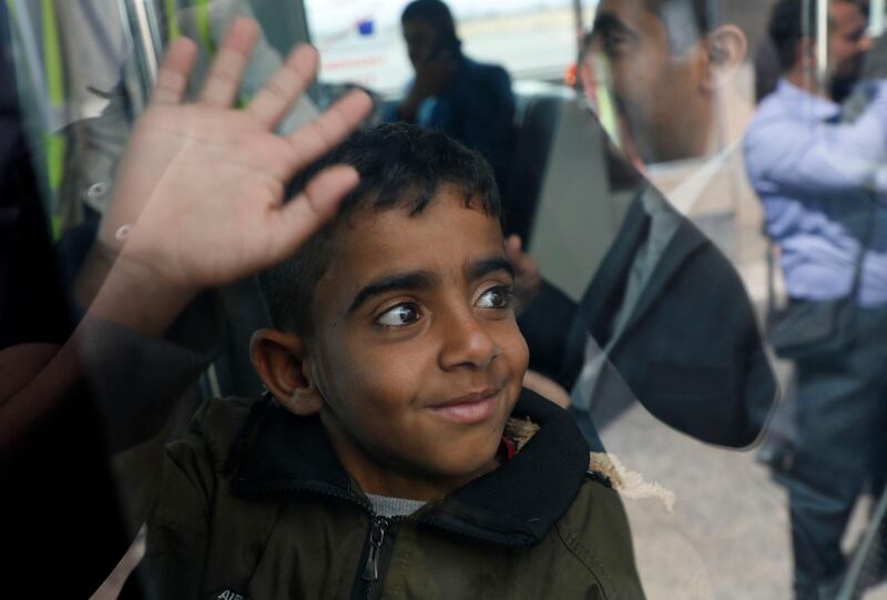 A Yemeni boy waves from inside a bus before boarding a United Nations plane at Sanaa International airport, Yemen. AP Photo