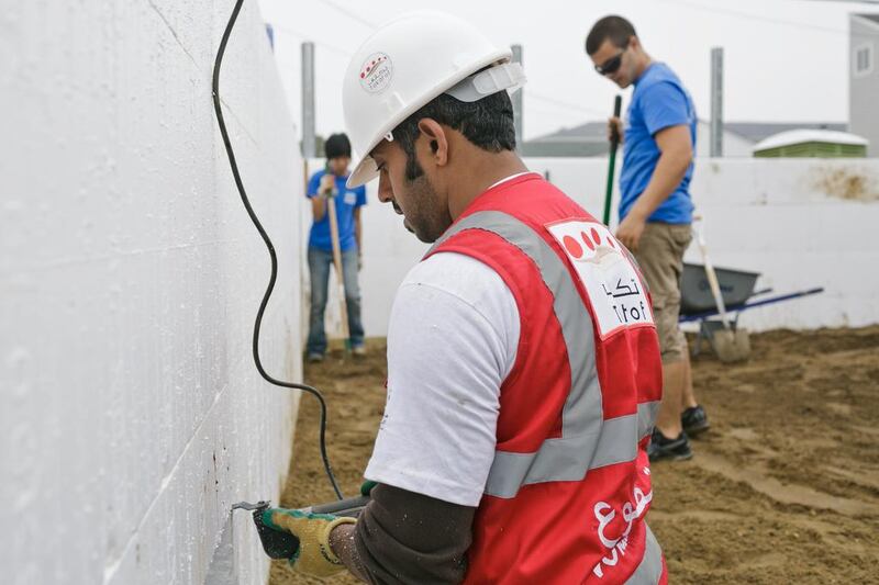 Taleb Al Blooshi, works on the house. he 12 young Emirati men and women who spent last week helping to renovate and build houses in New Jersey, including Ms Morris’s, aim to contribute to the rebuilding effort and also to act as cultural ambassadors for their country.