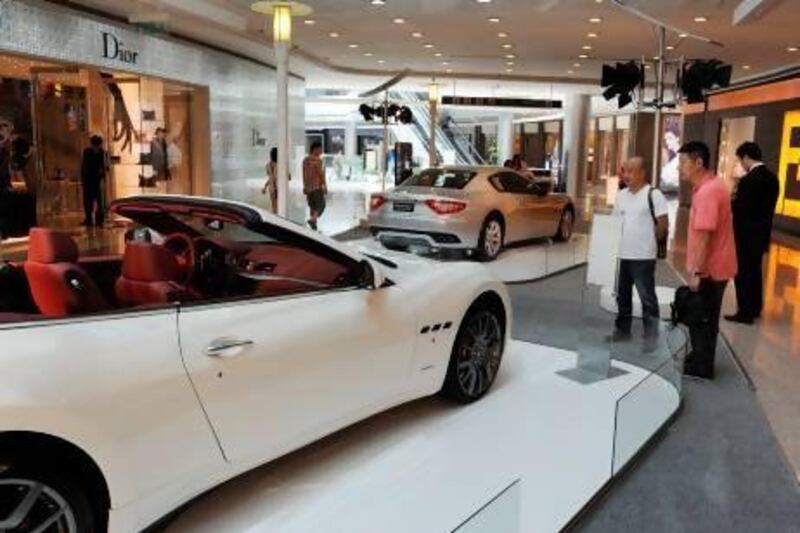A Maserati on display at a luxury mall in Shanghai draws onlookers. Mark Ralston / AFP