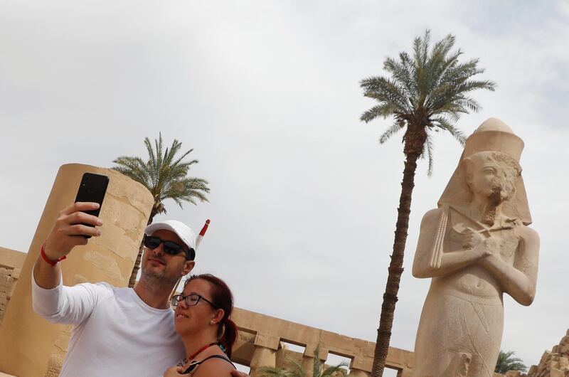 Tourists take a selfie picture with a mobile phone during their visit to Karnak Temple, following an outbreak of the coronavirus, in Luxor, Egypt March 9, 2020. REUTERS/Mohamed Abd El Ghany