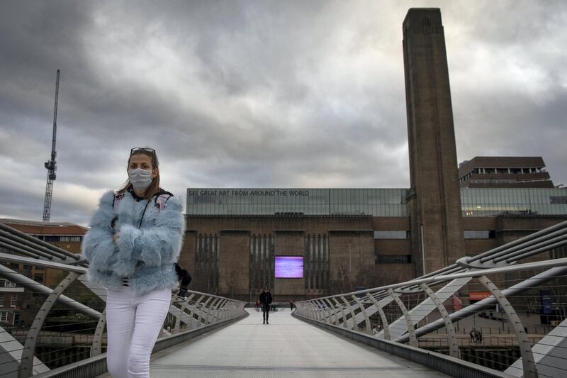 LONDON, ENGLAND - MARCH 17: A woman wearing a face mask walks over Millennium Bridge near the Tate Modern on March 17, 2020 in London, England. The Tate Modern has announced it will close it's doors from tomorrow amid the ongoing concern over COVID-19. Boris Johnson held the first of his public daily briefing on the Coronavirus outbreak yesterday and told the public to avoid theatres, going to the pub and work from home where possible. The number of people infected with COVID-19 in the UK reached 1500 today with 36 deaths. (Photo by Dan Kitwood/Getty Images)