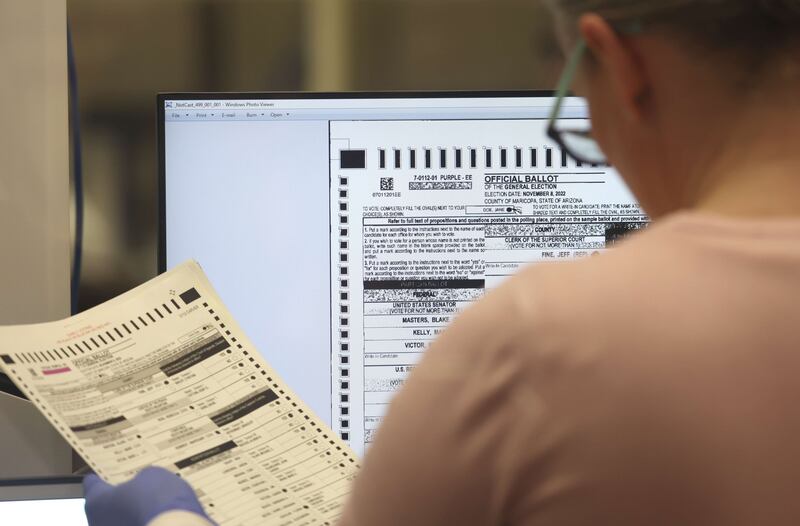 An election worker checks a ballot at the Maricopa County Tabulation and Election Centre in Phoenix, Arizona. AFP