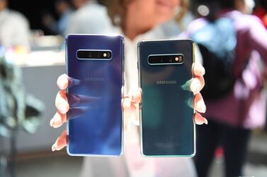 A Samsung employee displays a S10+ and a S10 phone during the product launch event in San Francisco. AFP 