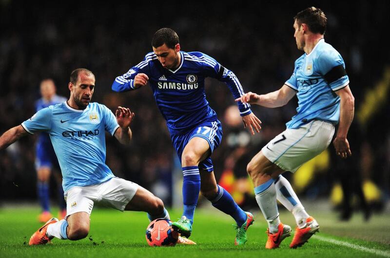 Hazard holds off the challenge of Pablo Zabaleta, left, and James Milner, right, on Saturday. Shaun Botterill / Getty Images