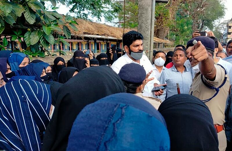 Parents argue with a police official during a protest outside a college in Udupi. AP
