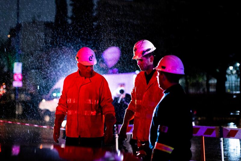 Technicians of Edenor electricity company stand under the rain as they work to fix a generator during a blackout in Buenos Aires, Argentina.  AP